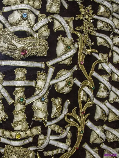 Reliquienschrein mit gold- und perlenumkleideten menschlichen Knochen und beschrifteten Namensbändern