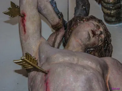 Nahaufnahme einer Sebastiansfigur: Pfeile stecken in Arm und Brust, Blut läuft über die Haut