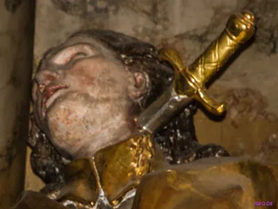 Kopf einer Märtyrerfigur, dem ein goldenes Schwert durch den Hals getrieben ist