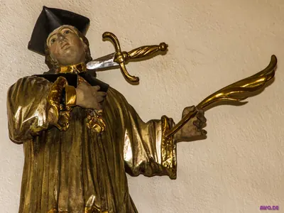 Vergoldete Figur des heiligen Johannes Nepomuk mit Birett, ein Schwert durchdringt seinen Hals