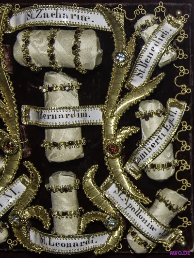 Reliquienkasten mit in Goldborte gefassten Knochen, beschriftet mit Heiligennamen