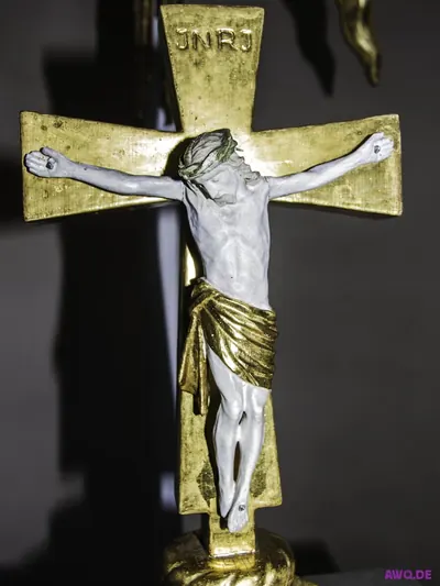 Vergoldetes Altarkreuz mit weißer Christusfigur und der Inschrift JNRJ