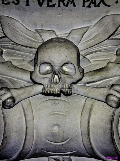 Steinrelief mit Totenschädel und gekreuzten Knochen unter der Inschrift „est vera pax“