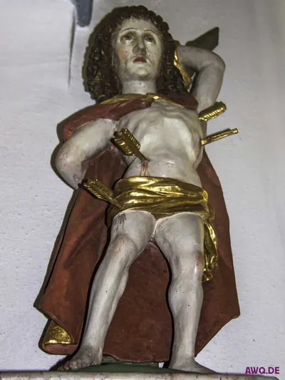 Sebastiansfigur im roten Mantel, Pfeile stecken in Brust und Rücken