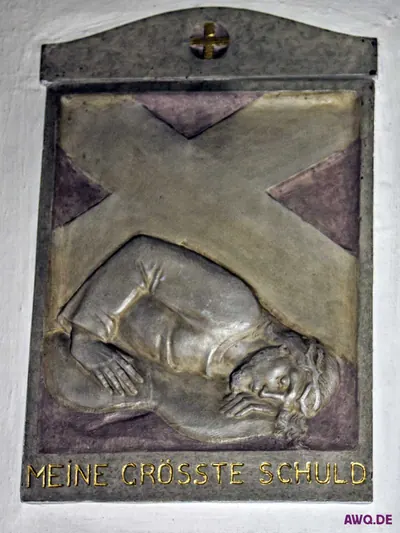 Bronzerelief einer Kreuzwegstation mit der Inschrift „Meine grösste Schuld“: Jesus liegt unter dem Kreuz am Boden