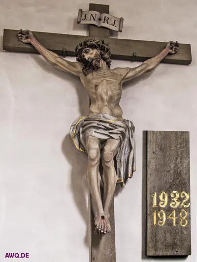 Kruzifix mit JNRJ-Tafel, daneben eine hölzerne Gedenktafel mit den Jahreszahlen 1932 und 1948