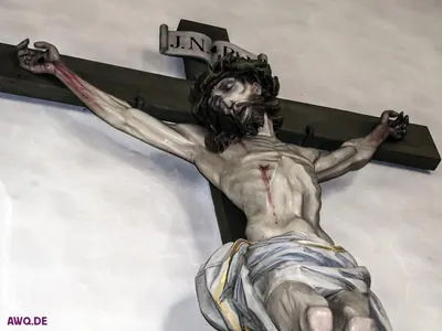 Kruzifixfigur mit Dornenkrone und JNRJ-Tafel, Blut läuft über Arme und Brust