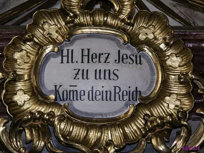 Vergoldete Kartusche mit der Inschrift „Hl. Herz Jesu zu uns, komme dein Reich“