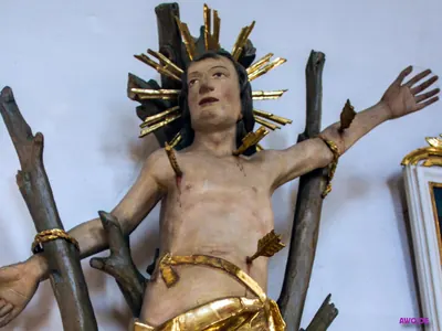 Christusfigur an einem Astkreuz mit goldenem Strahlenkranz, Blut auf der Brust