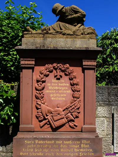 Kriegerdenkmal mit trauernder Soldatenfigur und Inschrift für die Gefallenen beider Weltkriege