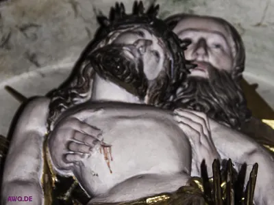 Nahaufnahme einer Pietà: das zurückgesunkene Haupt Jesu mit Dornenkrone, darunter eine blutende Wunde