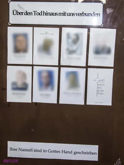 Gedenkwand mit unkenntlich gemachten Sterbebildchen unter der Aufschrift „Über den Tod hinaus mit uns verbunden“
