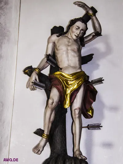 Sebastiansfigur am Baumstamm, Pfeile stecken in Brust, Arm und Bein