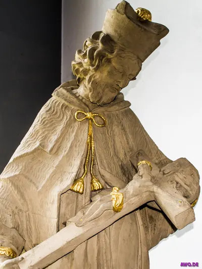 Steinfigur des heiligen Johannes Nepomuk, der ein Kruzifix im Arm hält