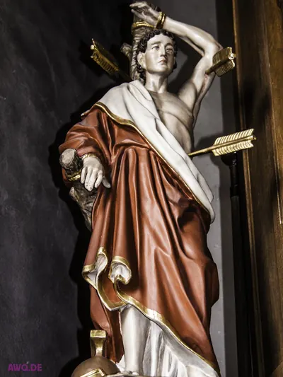 Sebastiansfigur im roten Mantel, der Arm nach oben gebunden, Pfeile in Arm und Seite