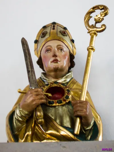 Bemalte Bischofsfigur mit Mitra und Krummstab, in den Händen ein Messer und eine ovale Reliquienkapsel