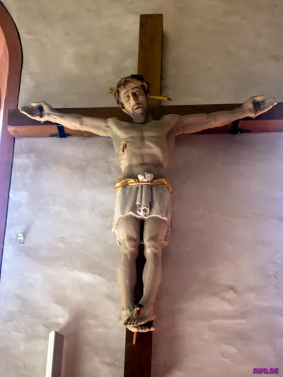 Großes Kruzifix an der Wand, Christusfigur mit Dornenkrone und bemaltem Lendentuch