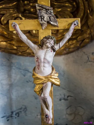 Vergoldetes Kreuz mit weißer Christusfigur, Blutspuren an Händen und Füßen
