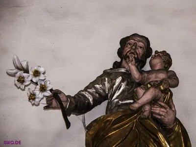 Figur des heiligen Josef mit weißen Lilien und dem Jesuskind auf dem Arm