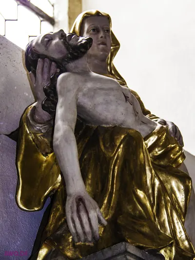 Pietà in Gold und Weiß: Maria stützt den Kopf des toten Jesus