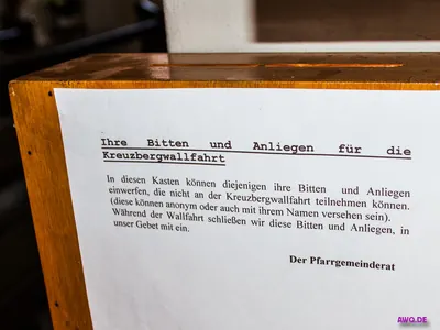 Holzkasten mit einem Aushang zu Bitten und Anliegen für die Kreuzbergwallfahrt
