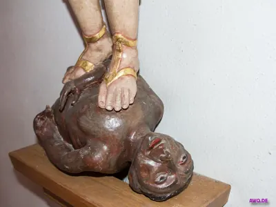 Detail: sandalenbeschuhte Füße stehen auf dem Oberkörper einer am Boden liegenden Teufelsgestalt