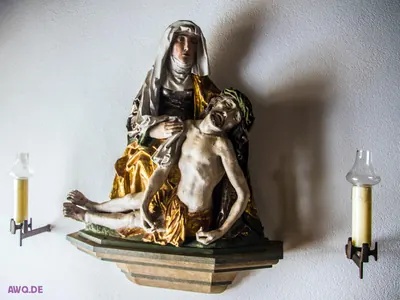 Pietà auf einer Wandkonsole zwischen zwei Kerzenhaltern