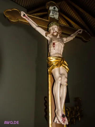 Kruzifix mit goldenem Lendentuch und blutigen Wunden auf einem vergoldeten Kreuz