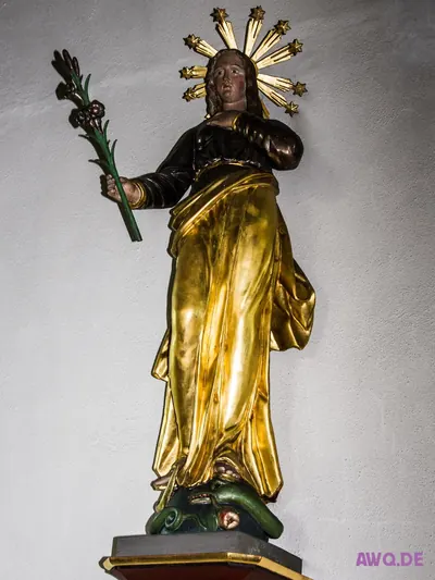 Vergoldete Marienfigur mit Sternenkranz, die auf einer grünen Schlange steht