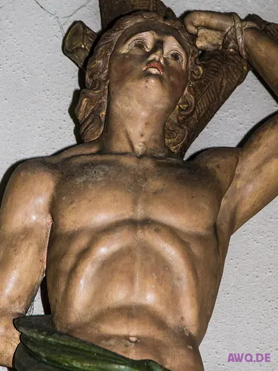 Nahaufnahme einer Märtyrerfigur mit nach oben gebundenen Armen