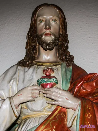 Herz-Jesu-Figur, die das von Dornen umwundene, brennende Herz in Händen hält