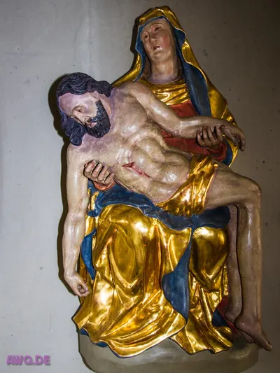 Pietà als Wandrelief: Maria in Gold und Blau hält den toten Jesus
