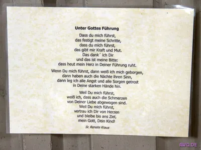 Aushang mit dem Gebetstext „Unter Gottes Führung“ an einer Wand