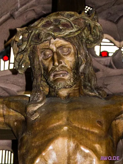 Nahaufnahme des Kopfes einer Christusfigur mit halb geöffnetem Mund und grüner Dornenkrone
