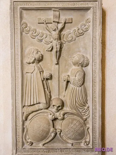 Steinernes Epitaph von 1569: ein knieendes Paar betet unter dem Kreuz, darunter ein Totenschädel